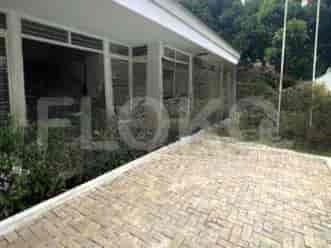 A modern house facade with a paved driveway, a covered walkway, and large windows.