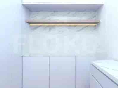 A modern interior featuring white cabinets, a wooden shelf, and a marble backsplash.