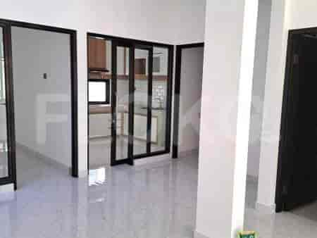 Sebuah bidikan interior yang menunjukkan lorong dengan dinding putih, lantai ubin yang mengkilap, dan pintu kaca yang mengarah ke ruangan yang berbeda.