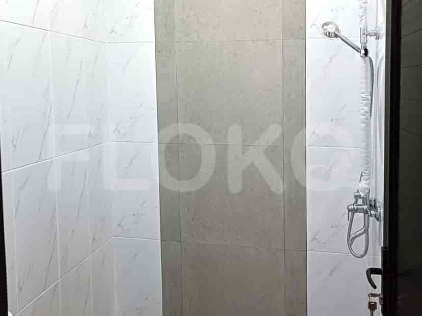 A shower with tiled walls.