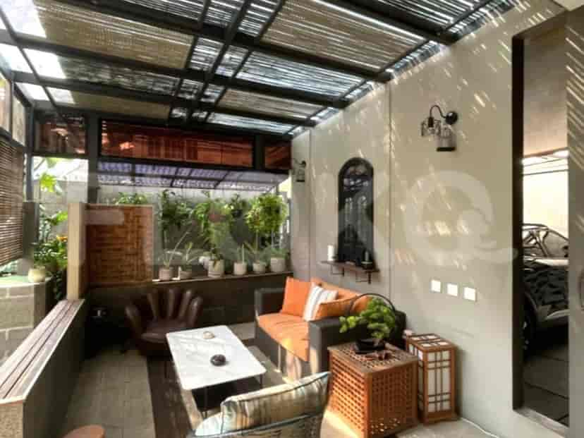 An outdoor terrace with seating, a coffee table, and a view of the garden.
