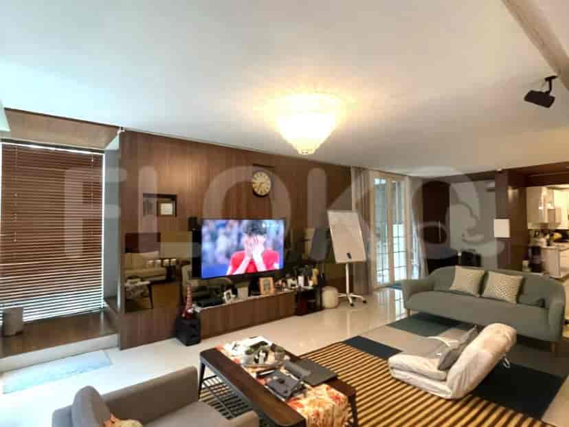 A living room featuring a large television, sofa, and a view of the garden.