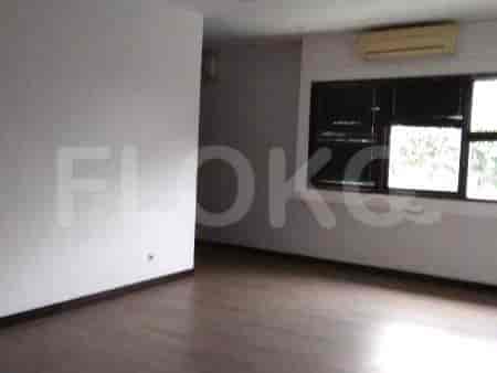 A living area with a window, wooden floors, and air conditioning.
