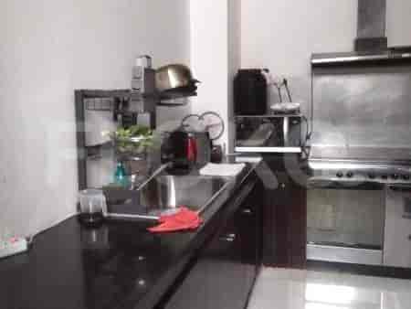 Another view of the kitchen with black countertop and stainless steel appliances.