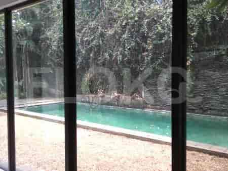 A swimming pool area with a large, rectangular pool surrounded by lush greenery.