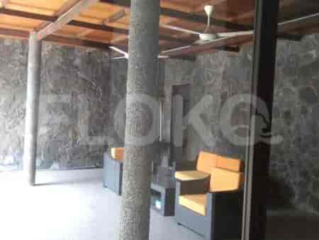 An outdoor seating area with stone walls and wooden beams.