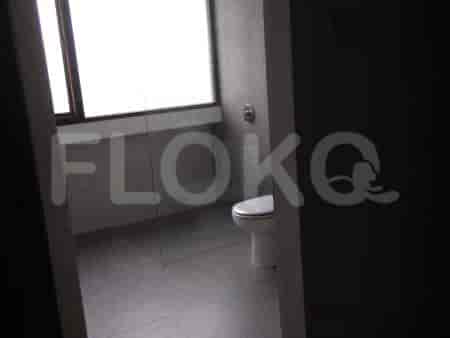 A modern bathroom with a toilet and a window.