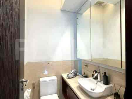 A modern bathroom with a white toilet, a sink, and a large mirror.