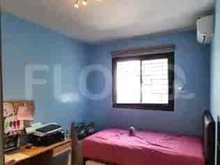 A bedroom with a single bed, a desk, and an air conditioner.