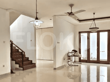 View of a living and dining space with access to the staircase and an open door.