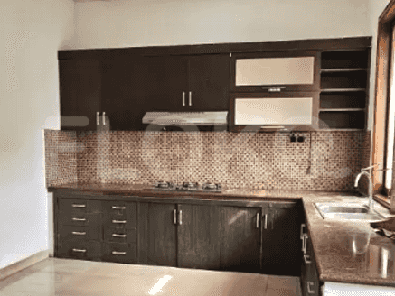A kitchen with dark brown cabinets, granite countertops, and a gas stove.