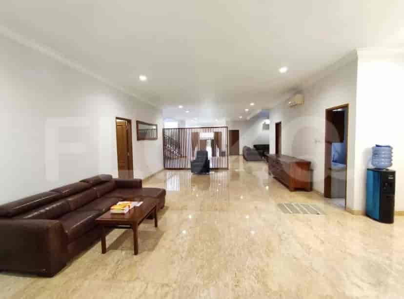 A large living room with marble flooring, a brown leather sofa, and a dining area.
