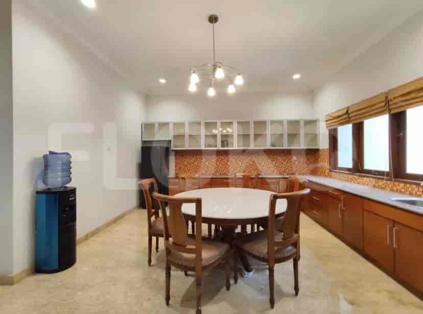 A kitchen with a dining area featuring a round table and chairs and a water dispenser.