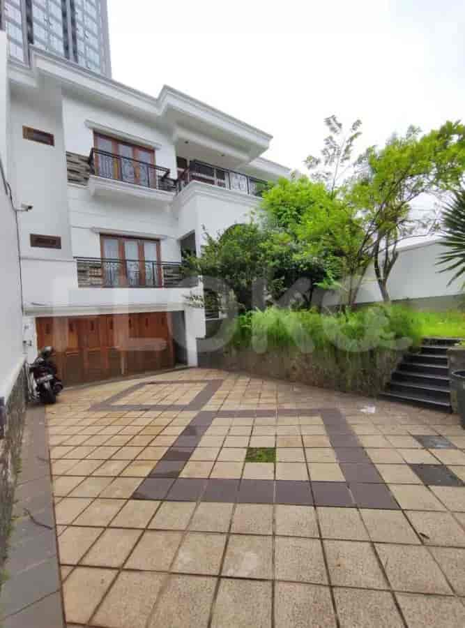 Exterior view of a modern two-story house with a paved driveway, wooden garage doors, and a small green lawn.