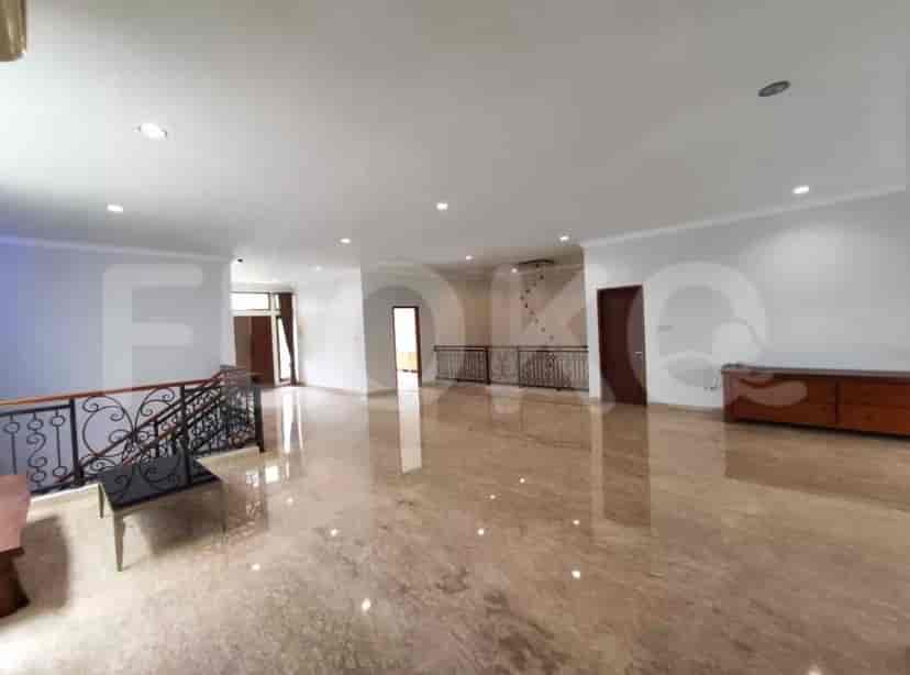 A bright open-plan second-floor area with marble flooring, a balcony, and wooden cabinetry.