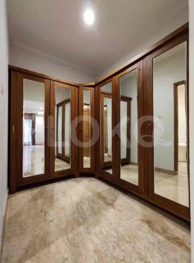 A bedroom featuring a large wardrobe, a walk-in closet, and marble flooring.
