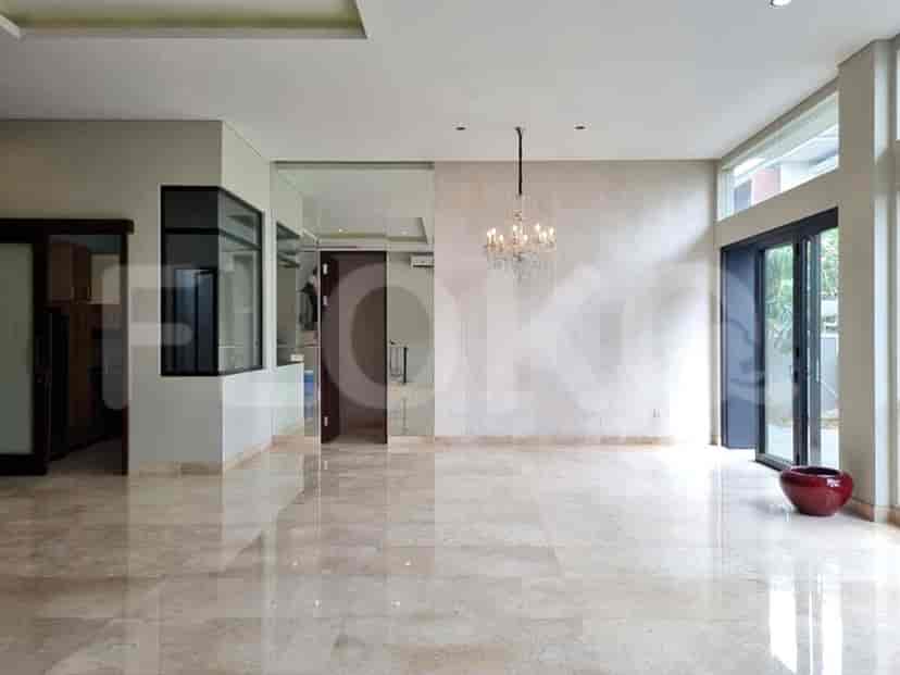 An open living room with marble floors, a chandelier, large windows, and an open door to the outside.