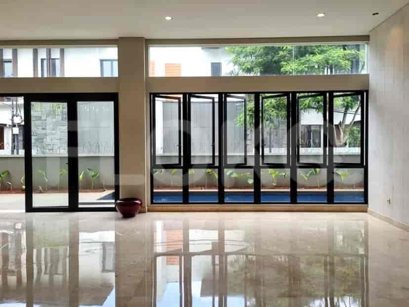 A spacious living room with multiple folding windows that open up to a swimming pool.