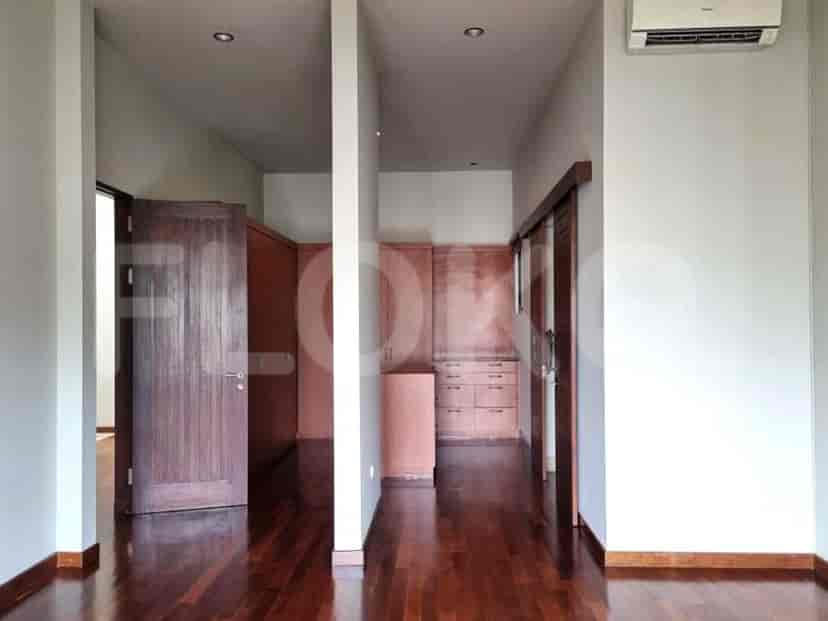 A hallway with dark wooden floors and doors leading to various rooms.