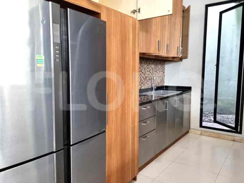A modern kitchen featuring stainless steel appliances, wooden cabinets, and a sink.