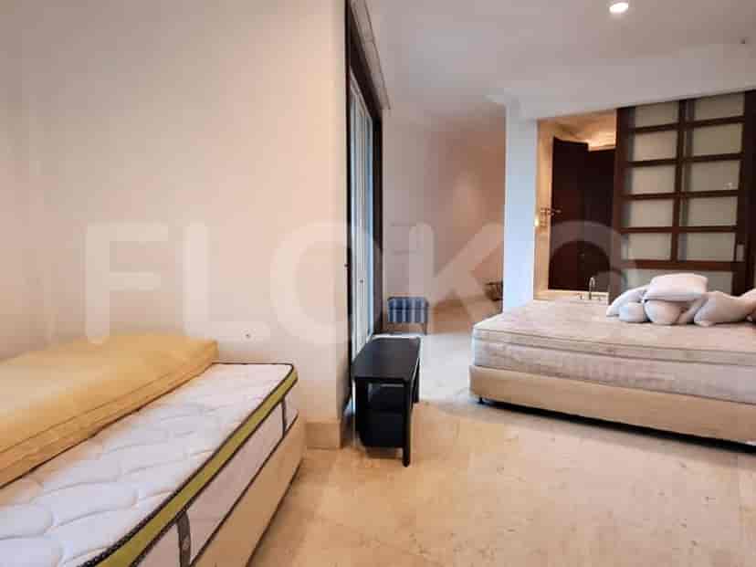 A bedroom with two beds and a bathroom access.