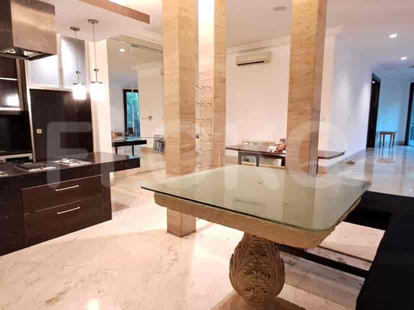A kitchen with granite countertops and a glass dining table.