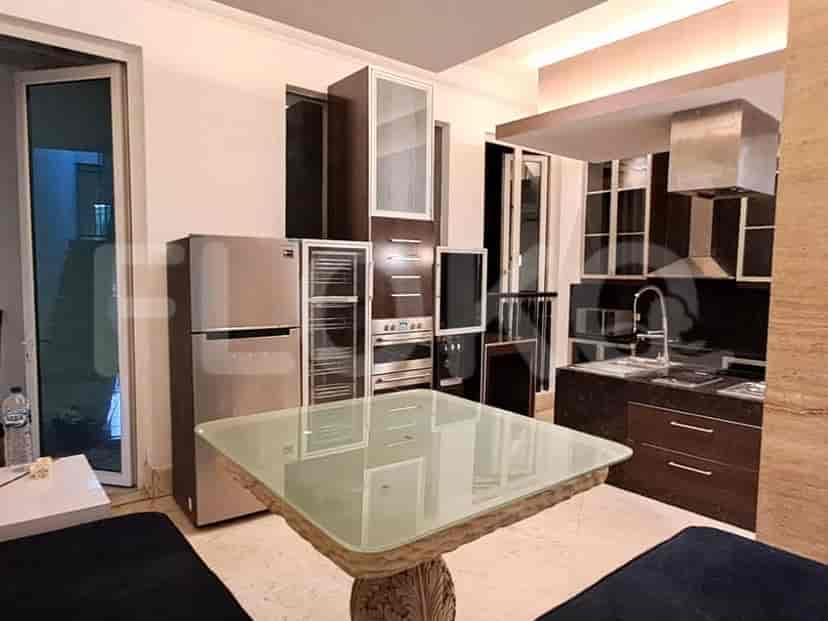 An open kitchen with stainless steel appliances and a dining table.