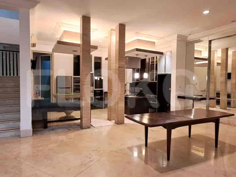 An open kitchen with wooden cabinets, granite countertops and a glass-top dining table.