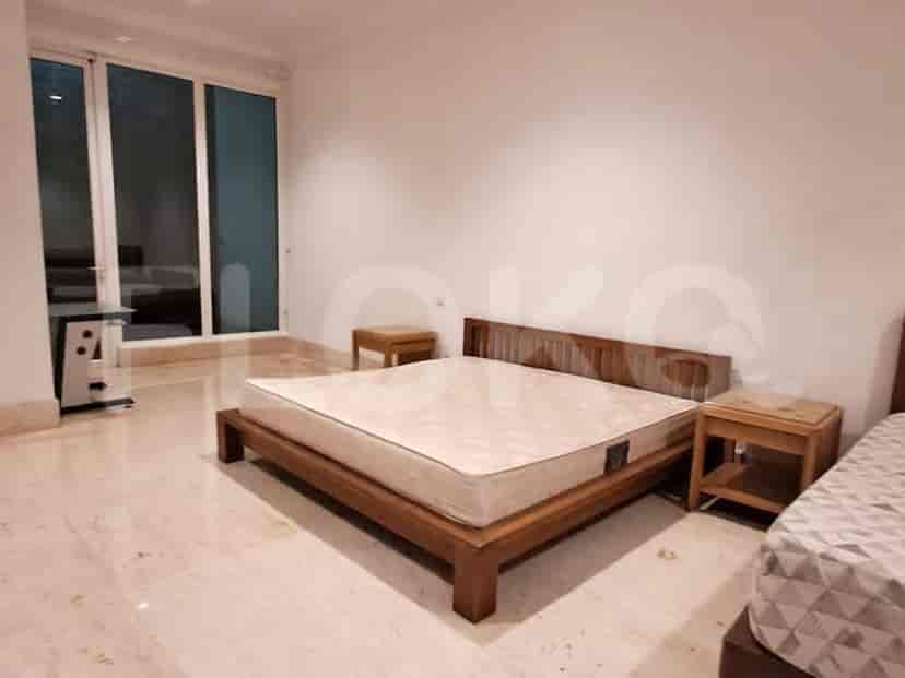 A bedroom with a wooden bed frame and nightstands.