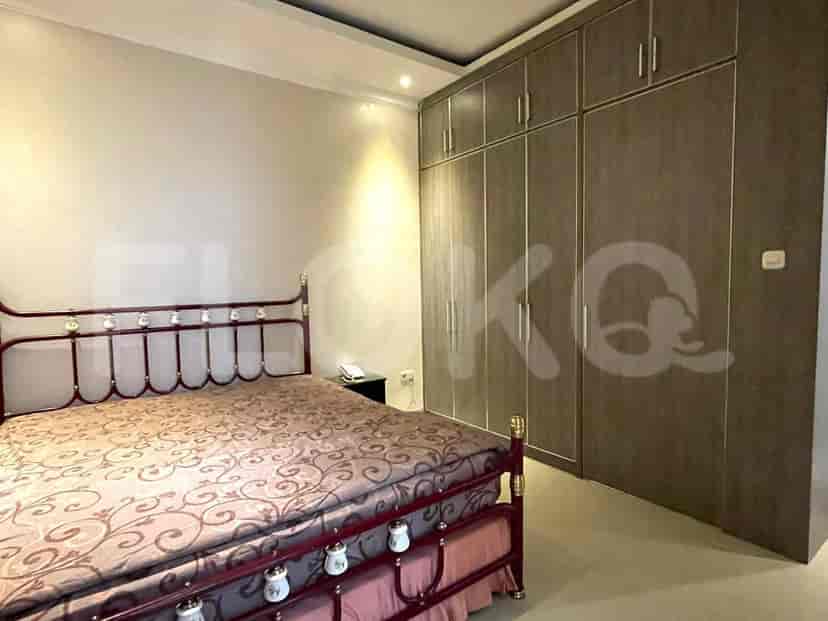 A guest bedroom with a metal framed bed, wardrobe, and nightstand.