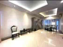 A dining area with a table, chairs, and a ceiling light fixture.