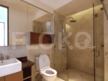 A modern bathroom featuring a walk-in shower, large mirror, and a white toilet.