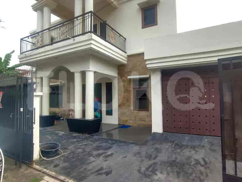 The front view of a two-story house with a balcony and a gate.