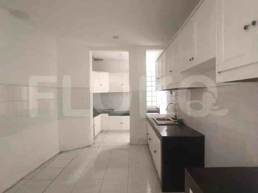 The kitchen area with white cabinets and a dark countertop.