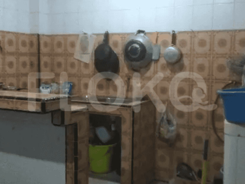 A kitchen with a sink, various cooking equipment, and a tiled countertop.