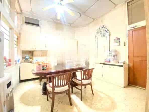 Area dapur dan ruang makan dengan meja kayu, kursi, dan lemari putih.