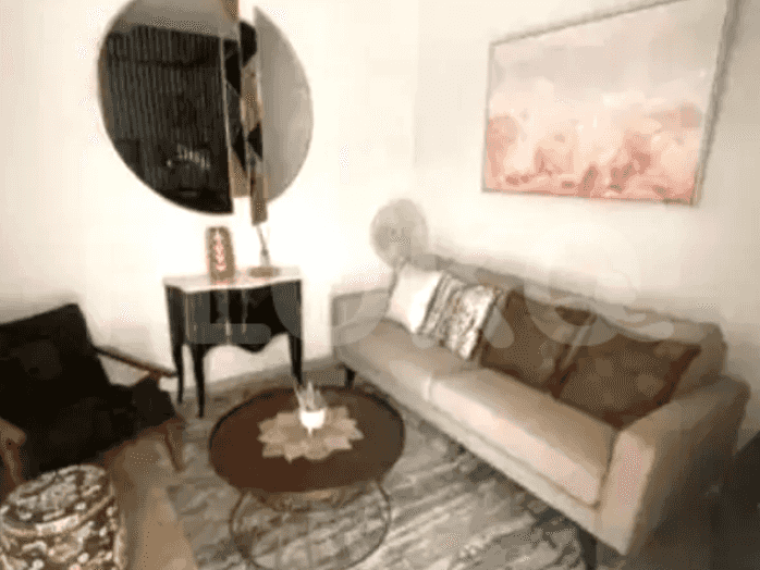 A living room with a sofa, round coffee table, and a large mirror.