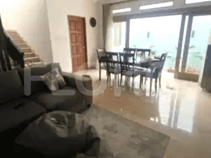A dining room with a dining table and chairs, with glass doors opening to a view.