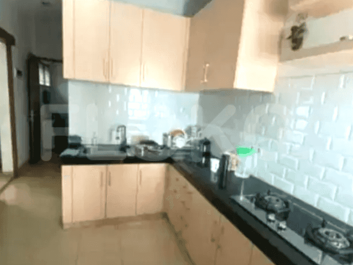 A modern kitchen with a gas stove, overhead cabinets, and black countertops.