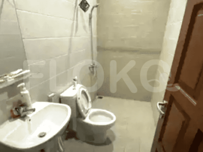 A bathroom with a toilet, sink, and a shower.