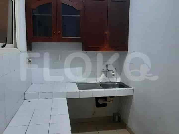 Dapur dengan lemari kayu, wastafel, dan backsplash berubin.