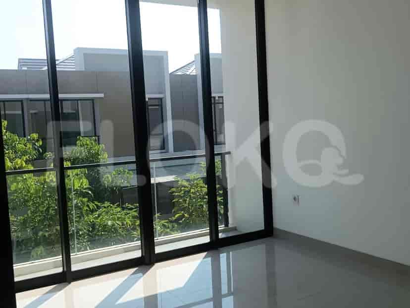 Pemandangan interior dengan jendela besar dan pemandangan area hijau yang rimbun di luar.