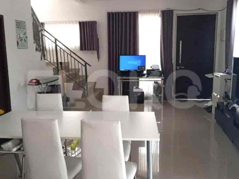 A living room with dining area and a staircase leading upstairs.