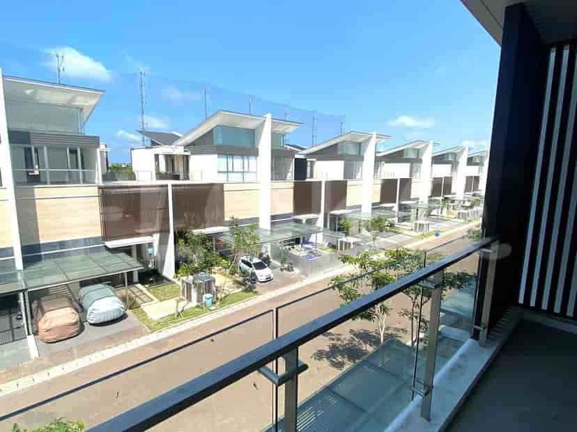 Pemandangan beberapa townhouse dengan balkon dan lapangan golf di latar belakang.