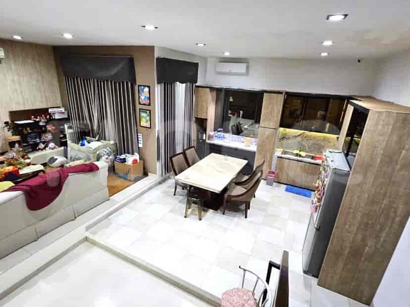 Area ruang tamu dan makan terbuka dengan lantai berubin, perabotan modern, dan jendela besar.