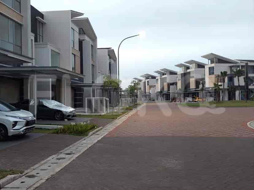 Pemandangan jalan perumahan dengan beberapa rumah modern.