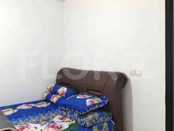 A bedroom with a double bed featuring a patterned bedspread and blue pillows.