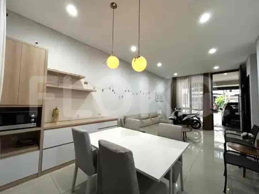 Area makan yang terintegrasi ke dalam ruang terbuka, menampilkan meja, kursi, dan lampu gantung.