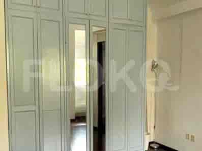 Kamar tidur yang dipenuhi cahaya dengan langit-langit miring, dua jendela, dan estetika minimalis.