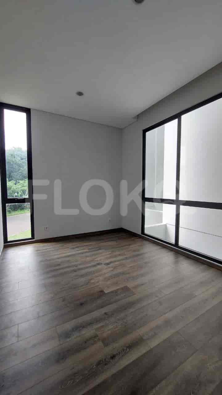Kamar tidur yang menampilkan jendela besar dengan pemandangan alami dan lantai kayu.